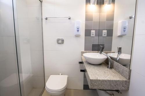 a bathroom with a toilet and a sink at Hotel Santa Cruz in Santa Cruz do Sul