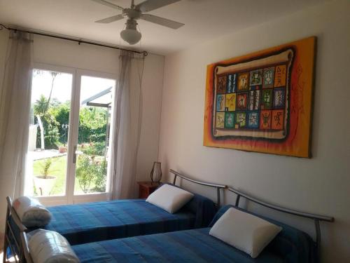 deux lits dans une chambre avec une fenêtre dans l'établissement Le gite le goeland a 5 km de la mer, à Fréjus