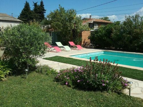 - une piscine avec des chaises roses dans la cour dans l'établissement Le gite le goeland a 5 km de la mer, à Fréjus