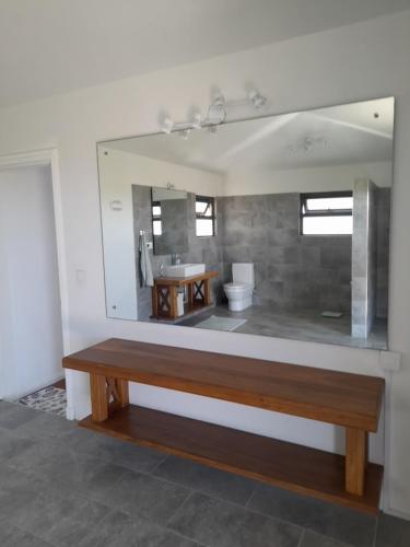 eine Bank im Bad mit Spiegel in der Unterkunft Jags villa in Plaine Magnien