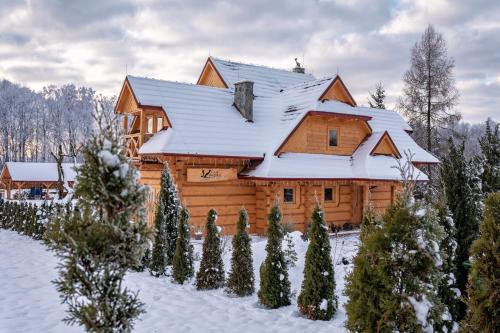 a log cabin with snow on the roof at VILLA MAZURIS in Pierkunowo
