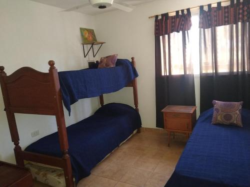 1 dormitorio con 2 literas con sábanas azules en Quebracho blanco en Bialet Massé