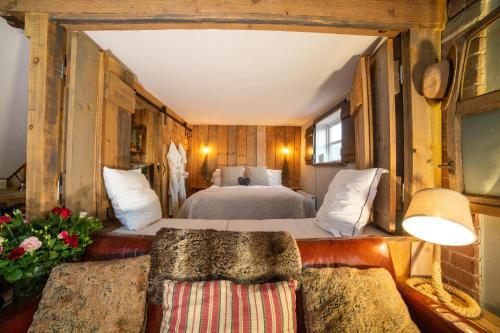 a bedroom with a bed and two couches at The Cowshed at Cheshire Boutique Barns in Nantwich