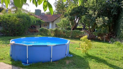a blue tub sitting in the grass in a yard at Casa de Huéspedes Muñiz sobre parque de 1000m2, 1 dormitorio, 20m2 cubiertos, baño con ducha, pileta cilíndrica de 3x076 in Muñiz