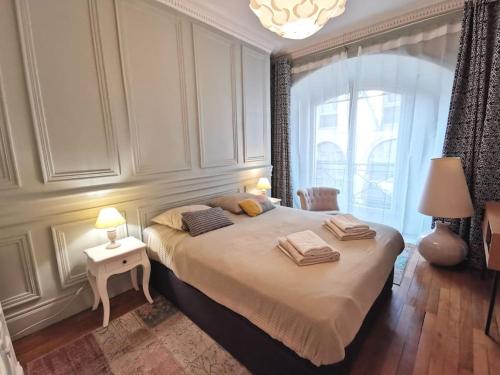 南特的住宿－Le Royal Couëdic - Les Maisons de Madeleine，一间卧室设有一张大床和一个窗户。