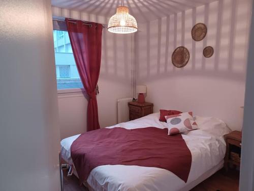 - une chambre avec un lit doté d'un rideau rouge et d'une fenêtre dans l'établissement Le François 1er : Au cœur de la ville, côté mer, au Havre