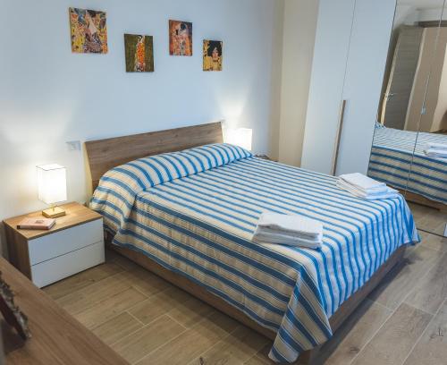 a bedroom with a bed with a blue and white striped blanket at Casa del Cocciaro in Città della Pieve