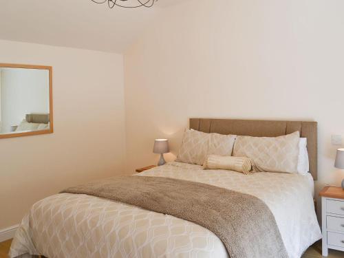 a bedroom with a large bed and a mirror at Mays Mews in binbrook