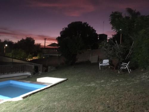 um quintal com uma piscina à noite em casa de marta a 50 mts del centro em Villa Carlos Paz