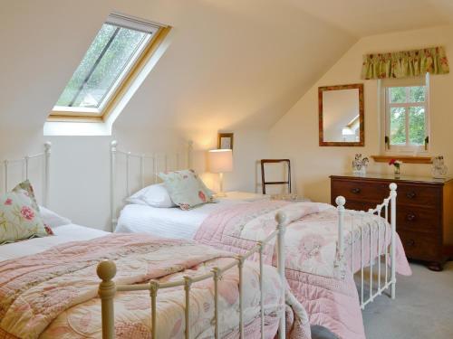 two beds in a attic bedroom with a window at Little Blackhall Lodge in Banchory