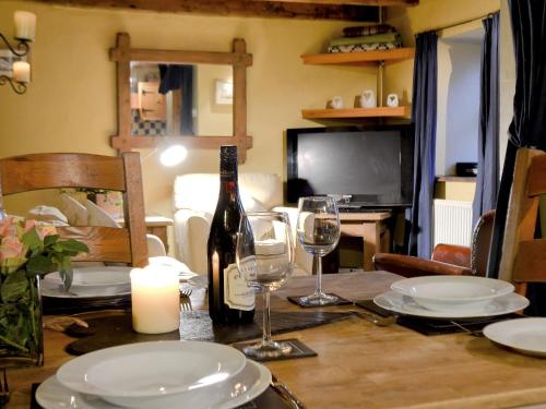 a dining table with a bottle of wine and glasses at The Stables in Whitland