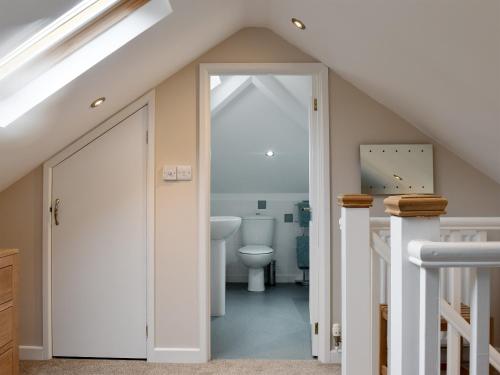 a bathroom with a toilet and a staircase at Brandelhow in Keswick
