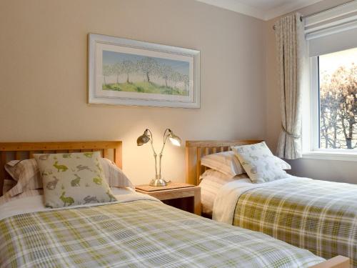 a bedroom with two beds and a window at Brandelhow in Keswick