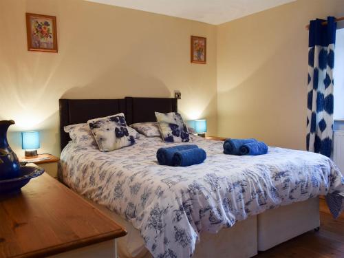 a bedroom with a bed with two blue pillows on it at Penrhiw in Llangeitho