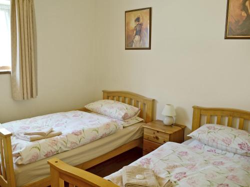 a bedroom with two beds and a table with a lamp at Felgate - E4287 in Thorpe Market