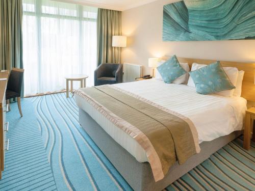 a hotel room with a large bed with blue pillows at Apartment 4 in South Cerney