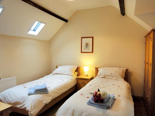 duas camas num pequeno quarto com duas toalhas em Bluebell Cottage - E4741 em Chipping Sodbury