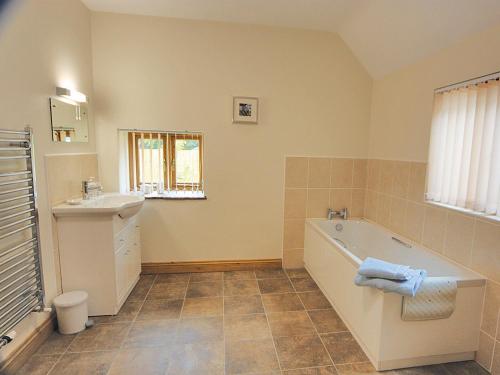 y baño con bañera y lavamanos. en Bluebell Cottage - E4741 en Chipping Sodbury
