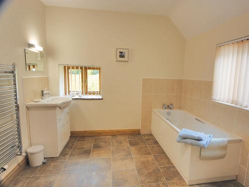 een badkamer met een bad en een wastafel bij Bluebell Cottage - E4741 in Chipping Sodbury