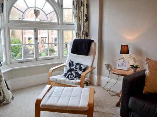 a living room with a chair and a window at The Broomes in Whitstable