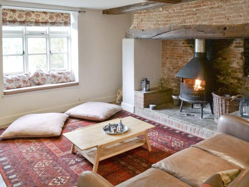a living room with a couch and a fireplace at Chapel Cottage in Sharrington