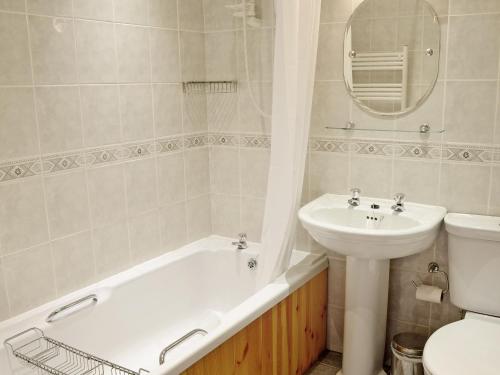 y baño con lavabo, bañera y aseo. en Copper View, en Coniston