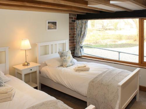a bedroom with two beds and a window at The Cart Shed in Tickton