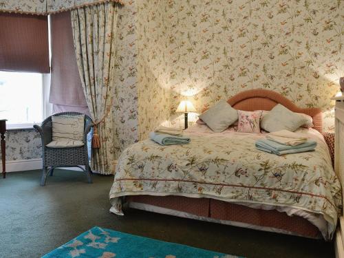 een slaapkamer met een bed, een stoel en een raam bij Maes Gwyn - Hw7644 in Llandudno