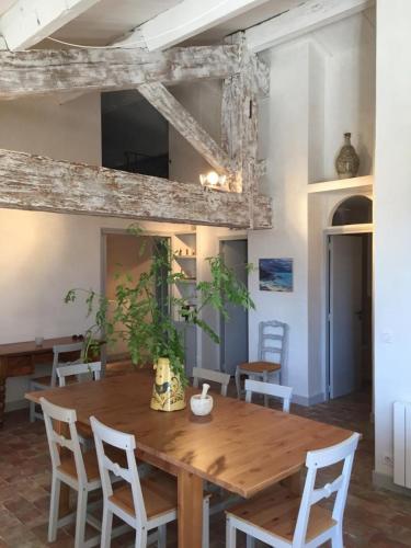 une salle à manger avec une table et des chaises en bois dans l'établissement Les vendangeurs a 800 m de la mer, à Bormes-les-Mimosas