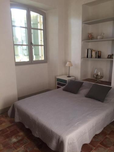 une chambre avec un grand lit et une fenêtre dans l'établissement Les vendangeurs a 800 m de la mer, à Bormes-les-Mimosas