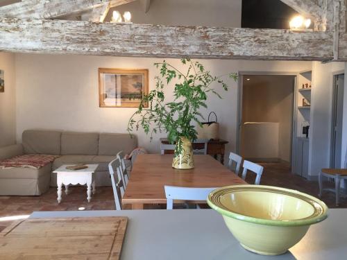 a living room with a wooden table with a vase on it at Les vendangeurs a 800 m de la mer in Bormes-les-Mimosas