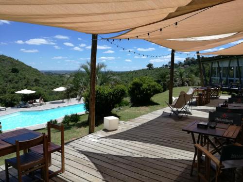 una terraza con mesas y sillas y una piscina en Villa Serrana - Mesón de las cañas, en Villa Serrana