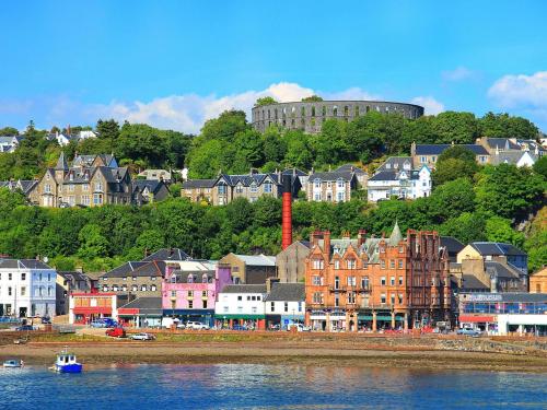 a group of buildings on a hill next to the water at Mull in Achnacroish