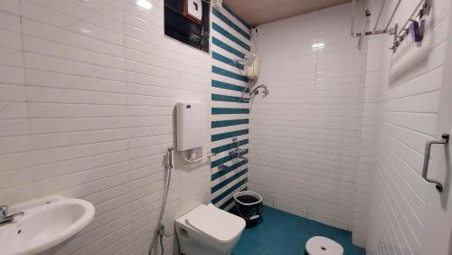 een witte badkamer met een toilet en een wastafel bij Soham Beach Resort, Diveagar in Diveagar