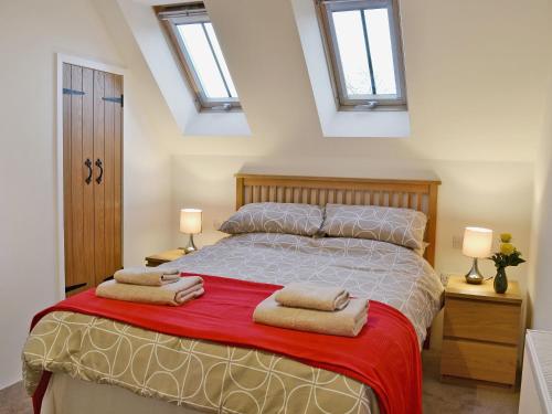 1 dormitorio con 1 cama con 2 toallas en Tiger, en Horsted Keynes