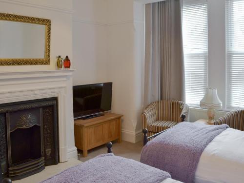 a bedroom with a fireplace and a bed and a television at Sandfield The Promenade in Southport