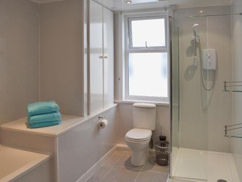 a bathroom with a toilet and a shower and a window at Sandfield The Promenade in Southport