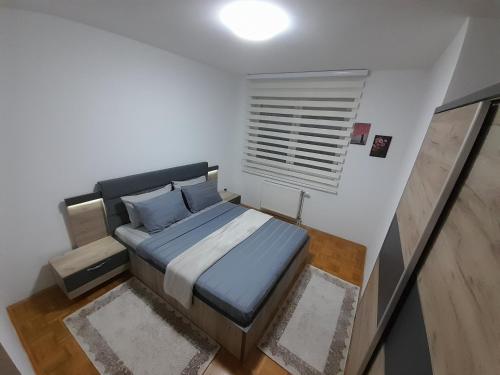 ein kleines Schlafzimmer mit einem Bett und einem Fenster in der Unterkunft Gray Apartment 1 Pristina in Pristina