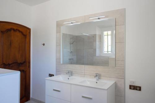 une salle de bain avec un lavabo blanc et un miroir dans l'établissement Hameau des molieres, à La Roquebrussanne