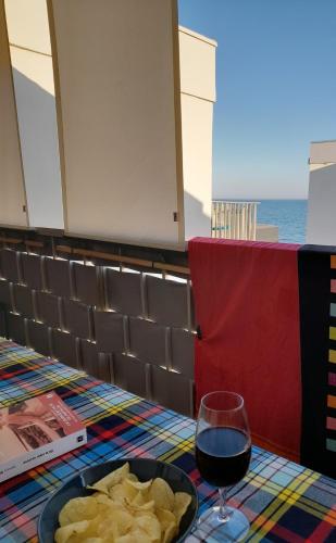 un plateau de frites et un verre de vin sur une table dans l'établissement Chez Isabelle et Virgile Bel appartement, avec vues, à 50m de la plage, à Palavas-les-Flots