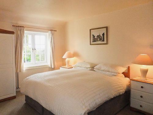 una camera con un letto bianco e una finestra di Monks Thatch a Otterton
