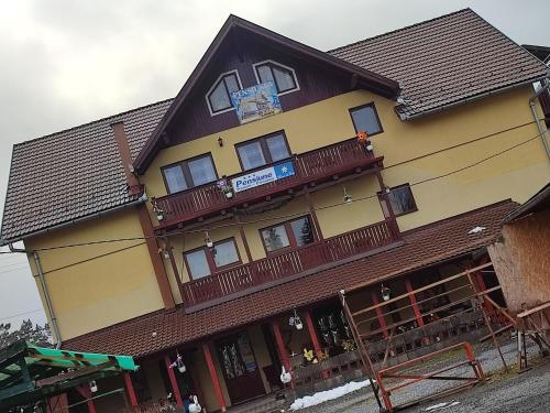 a yellow and brown building with a balcony at Edelweis Floare de Colt in Borsec