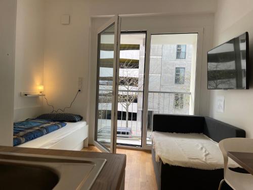 a bedroom with a bed and a large window at Myroom Business Apartment Nähe Messe München in Munich