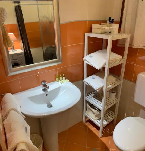 ein Badezimmer mit Waschbecken, Spiegel und Toilette in der Unterkunft Regal beach in Caorle
