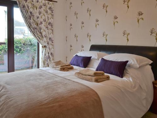 a bedroom with a large bed with towels on it at Ty Haf in Trearddur