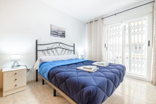 a bedroom with a large bed with a blue comforter at Benidorm Old Town House - Casa Casco Antiguo in Benidorm