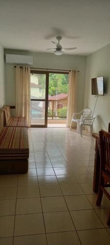 uma grande sala de estar com um sofá e uma mesa em Apartamento Climatizado a 150 Metros da Praia em Ubatuba
