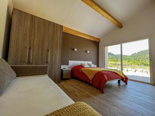 a bedroom with a bed and a large window at La maurette piscine chauffee in La Motte