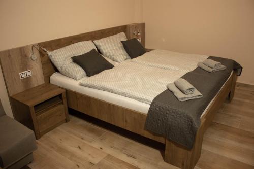 a large wooden bed with two towels on it at Apartmány Pilot in Velká Hleďsebe