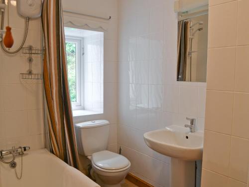 een badkamer met een toilet, een wastafel en een bad bij Oak Lea in Braithwaite